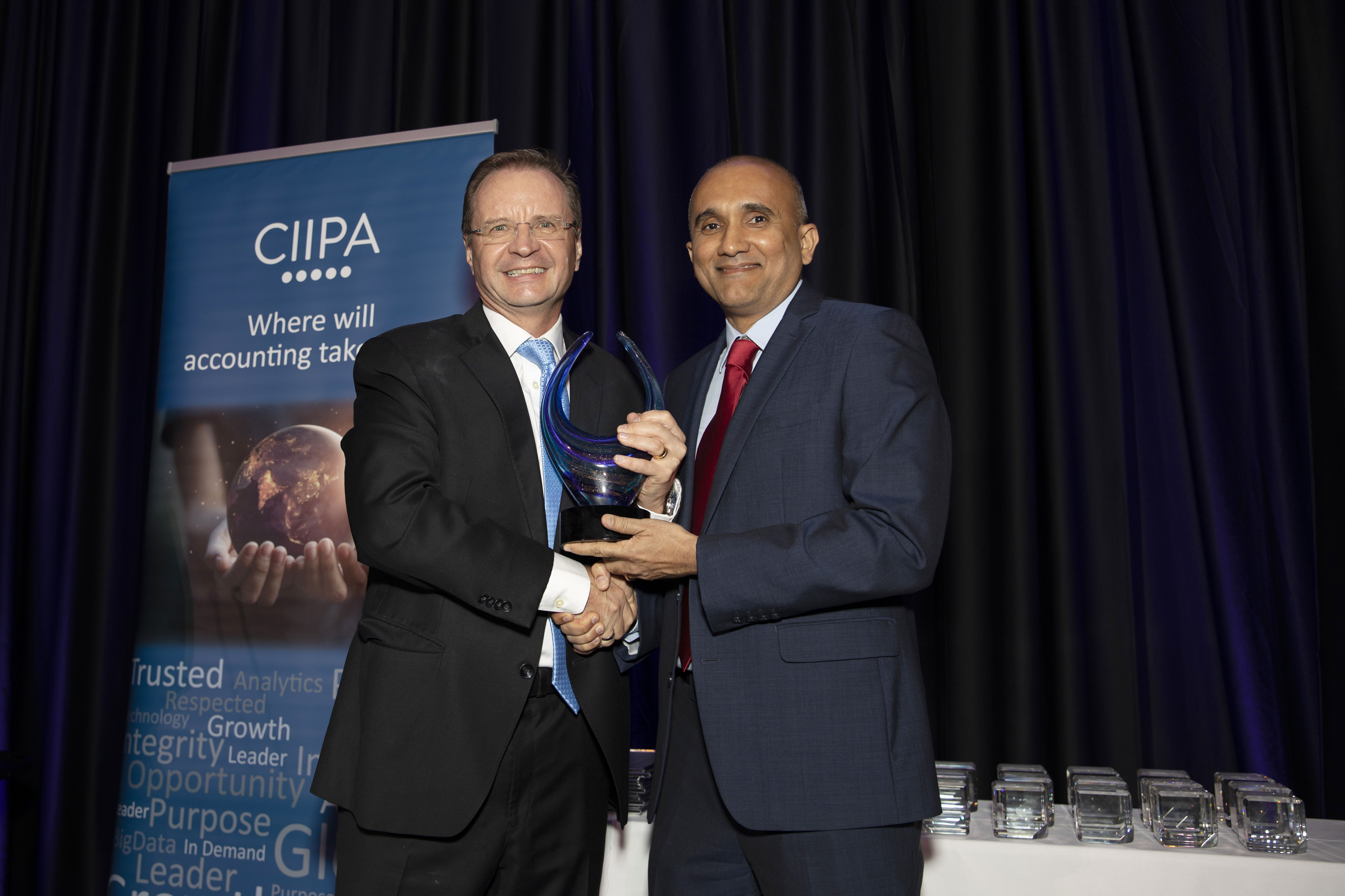 CIIPA President Rennie Khan, right, hands the Pioneer Award to recipient Charles Bolland during the 14th-annual CIIPA Awards Gala Saturday night (24 Sept.) at the Kimpton Seafire Resort and Spa.